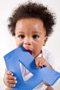 African American baby playing with the letter A, 6 months old